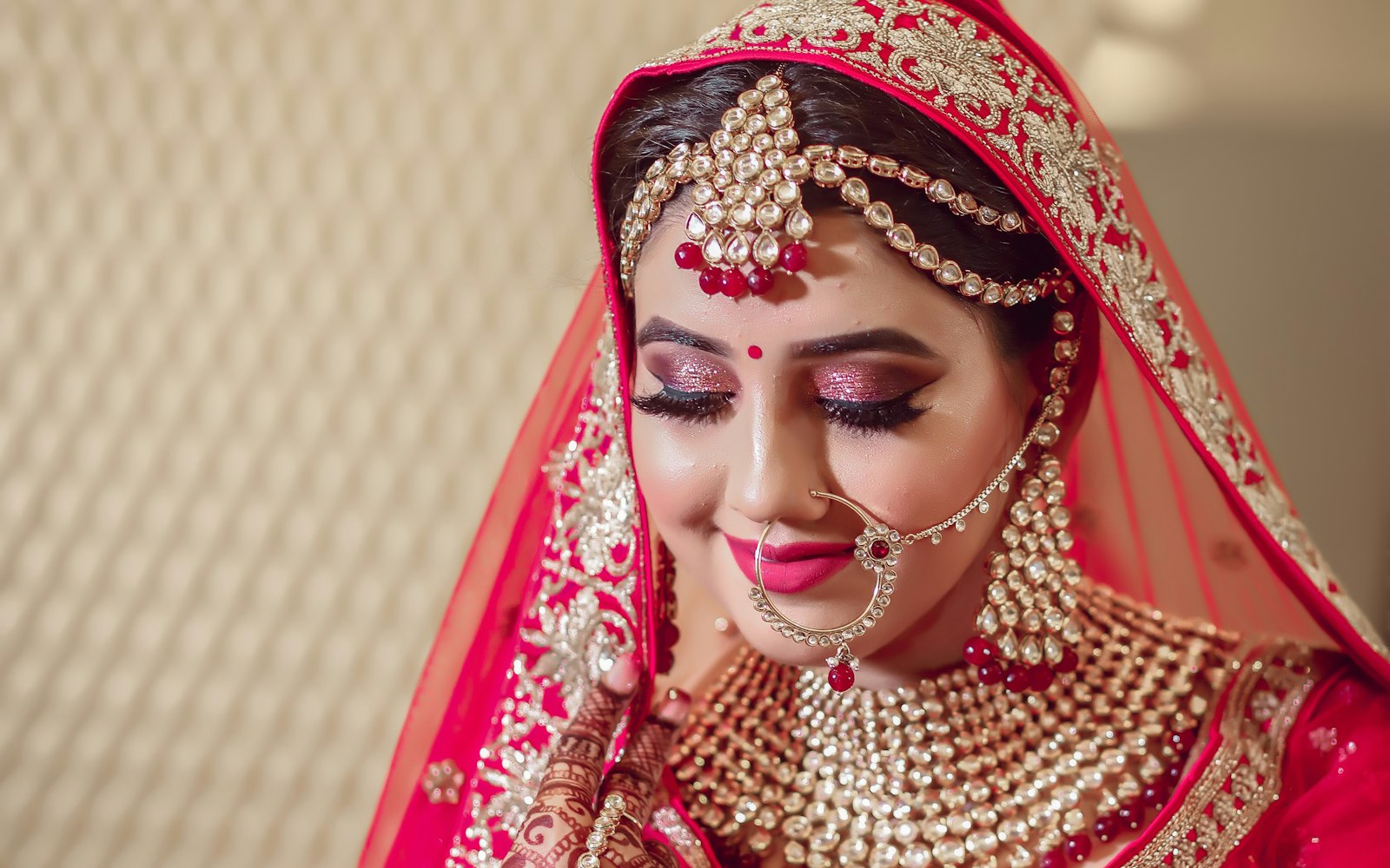 South Asian bride in red with full bridal makeup and jewelry
