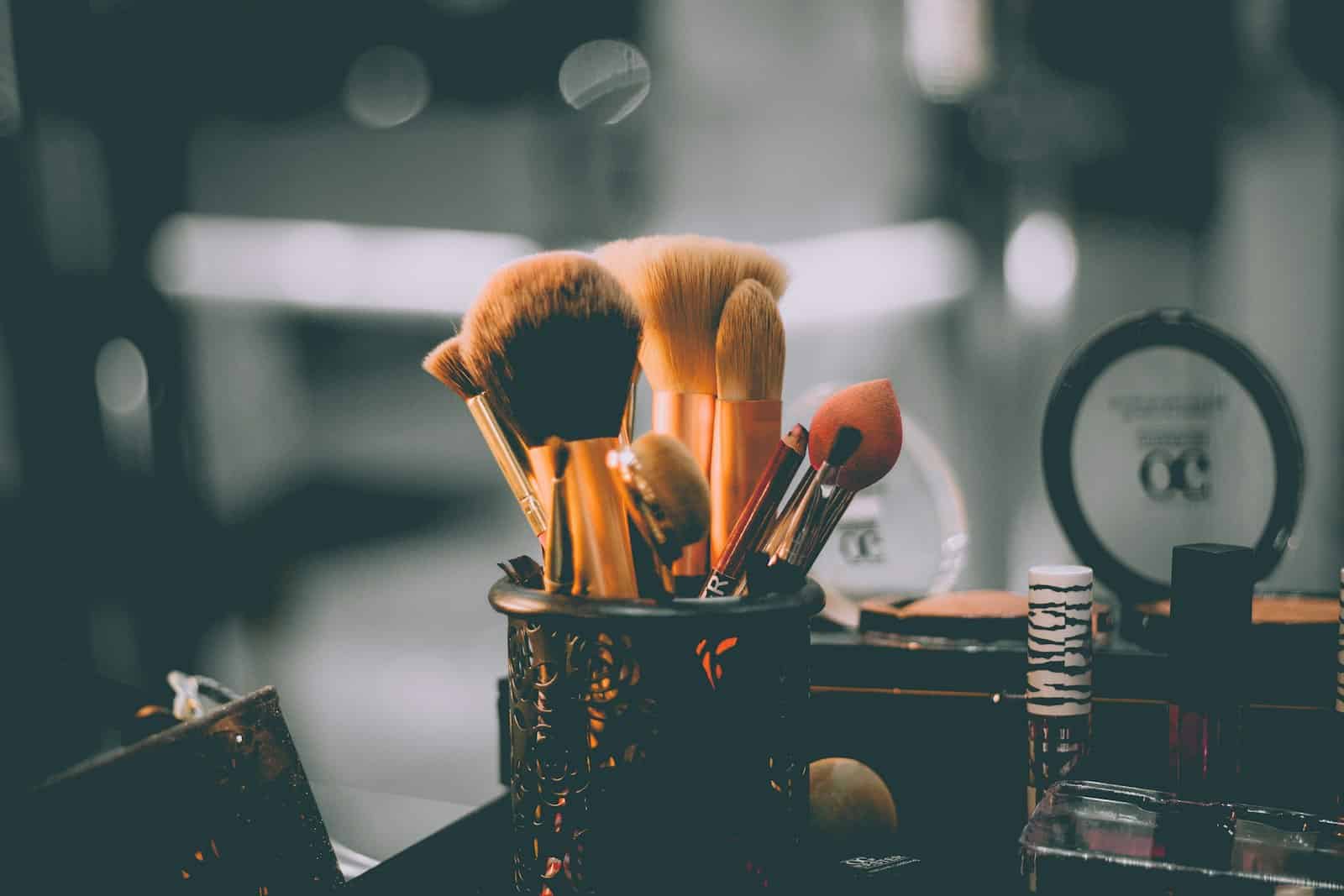 Makeup brushes standing in holders on a backstage table