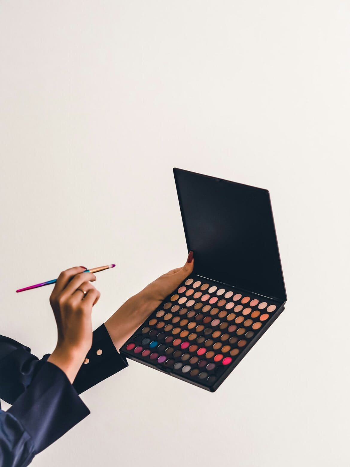 Makeup artist holding an eyeshadow palette and a brush