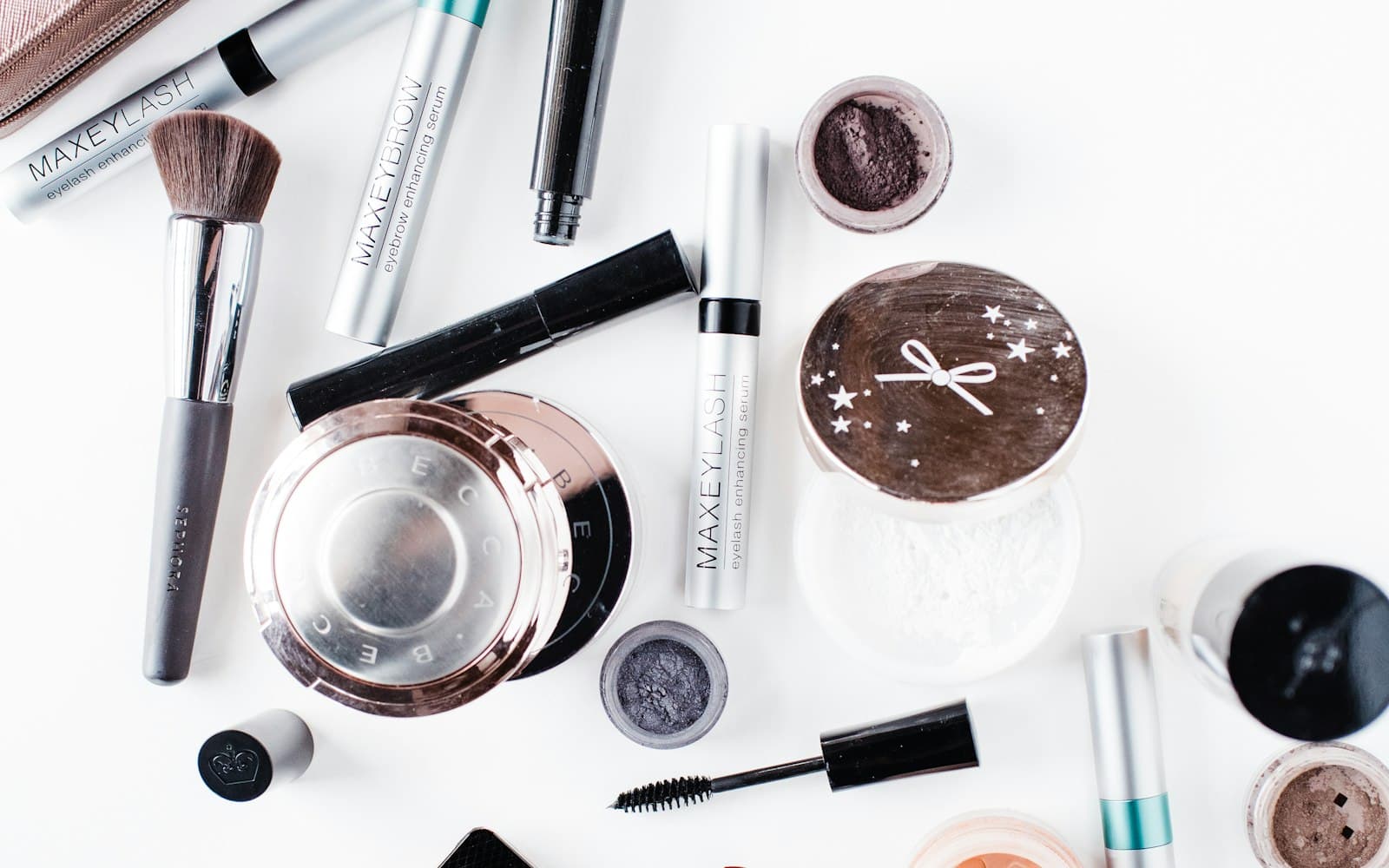 Makeup brushes and products laid out on a white desk