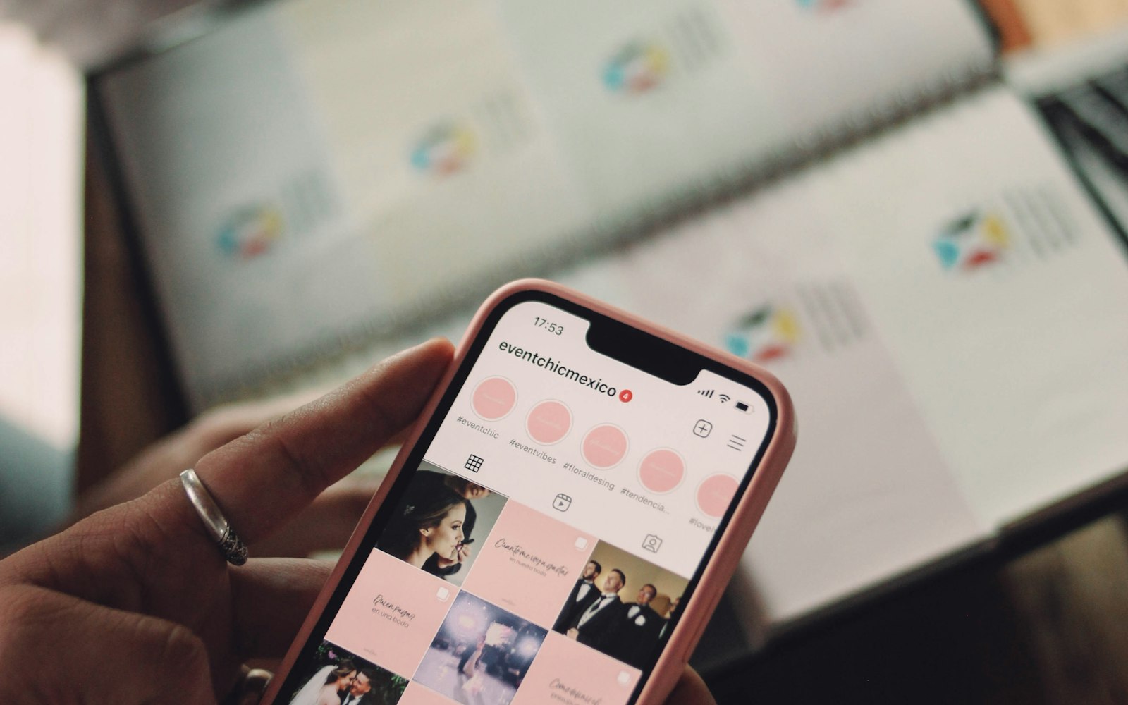 Hand holding a phone showing a wedding business Instagram profile