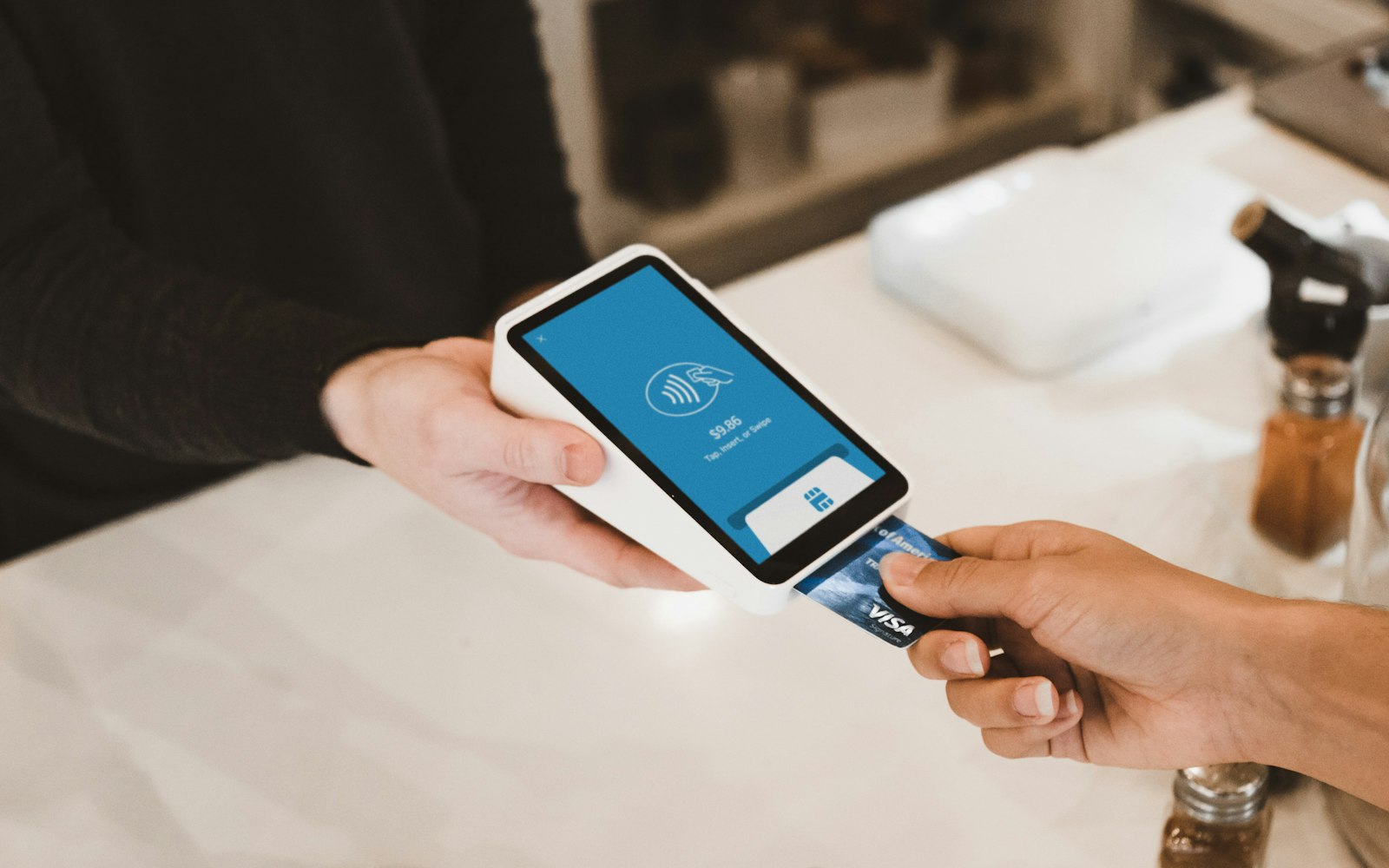 Client paying by card on a small countertop card reader