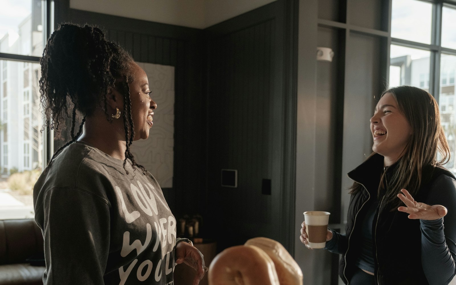 Two women talking and laughing indoors