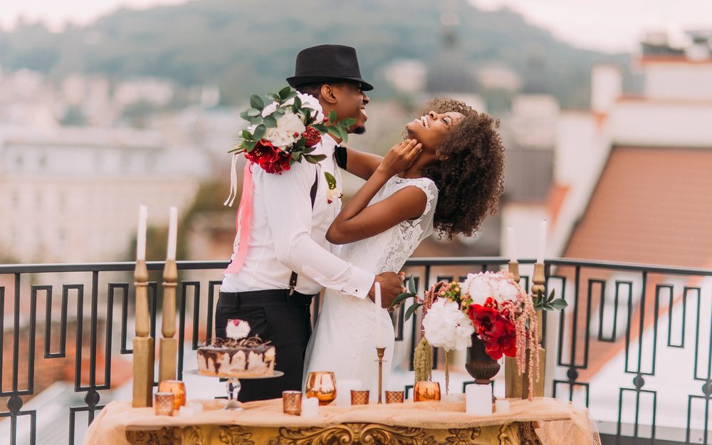 Wedding couple laughing together on a balcony