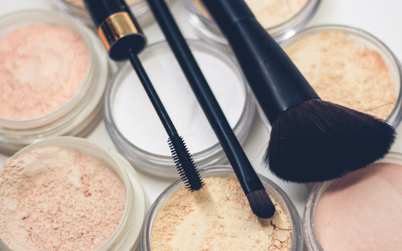 Loose powders in several skin tones with brushes