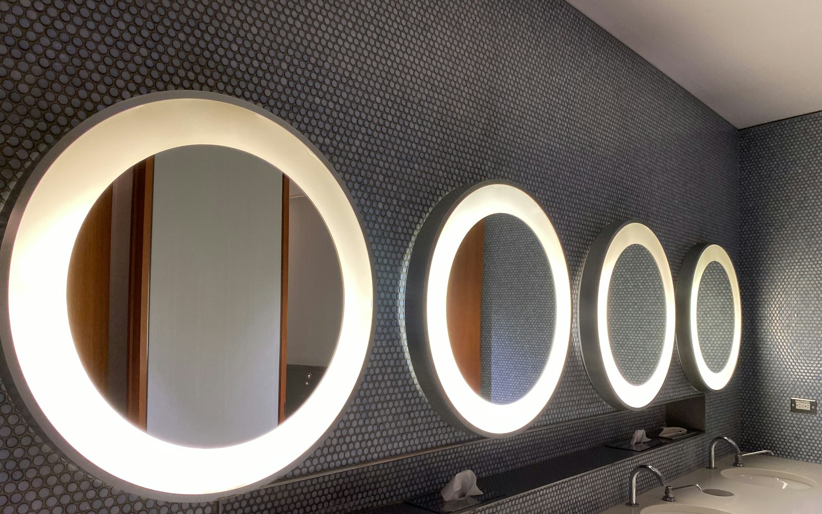 Row of round mirrors lit with warm light