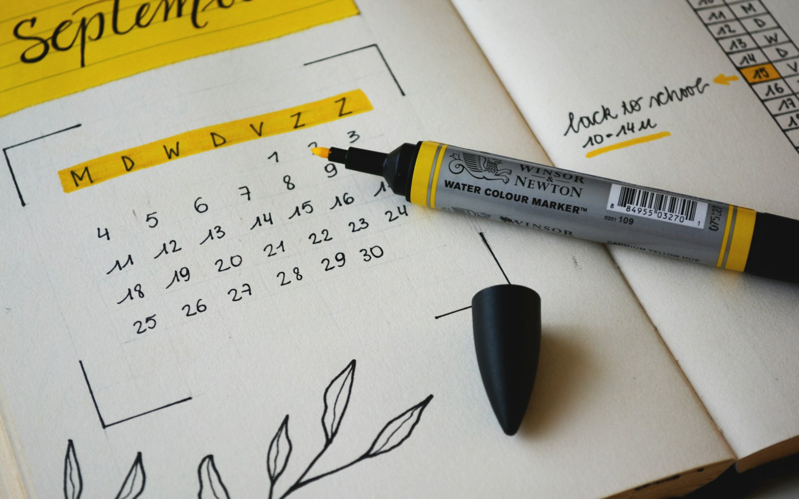 Hand-lettered monthly calendar with a marker