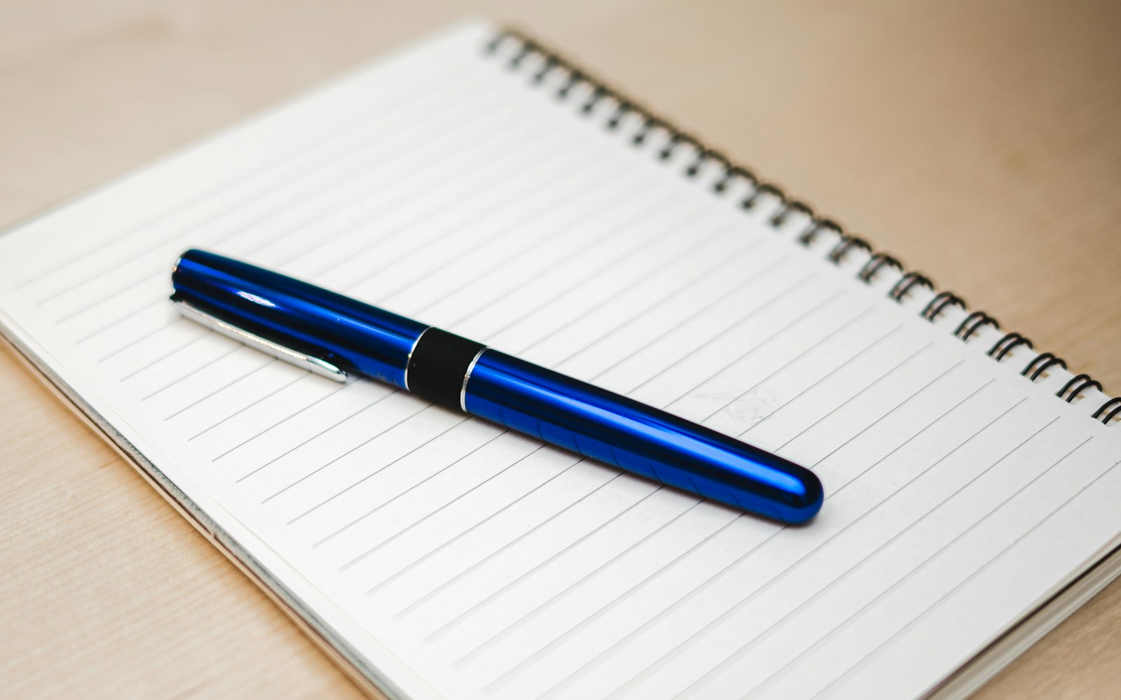 Blue pen on an open lined notebook