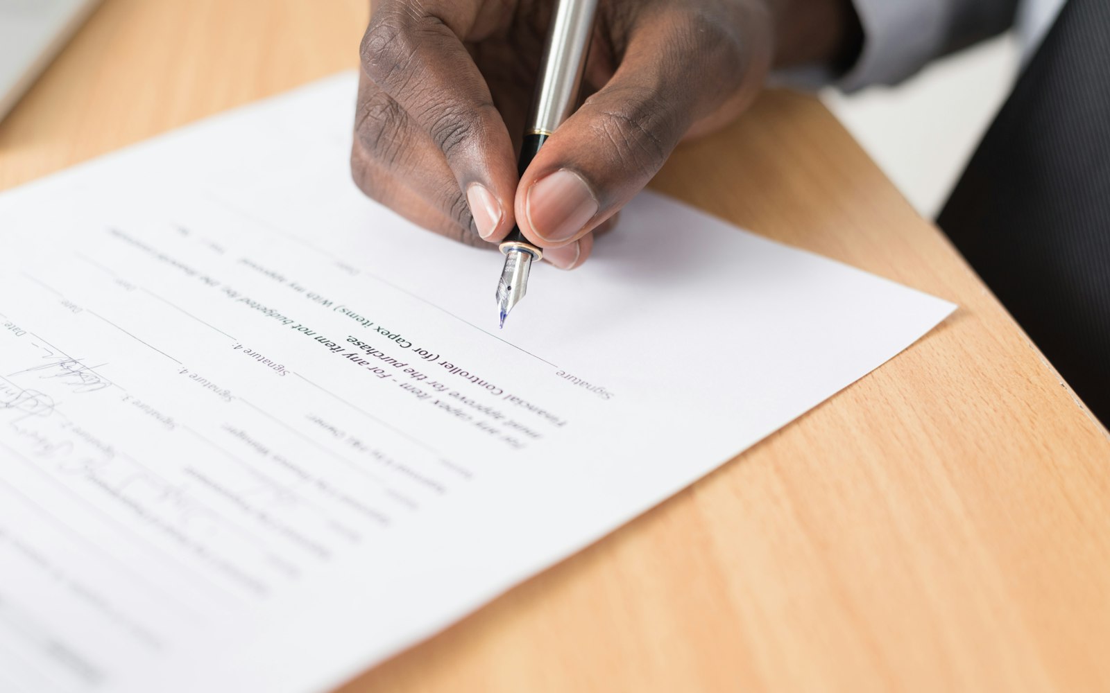 Hand signing a printed document with a fountain pen