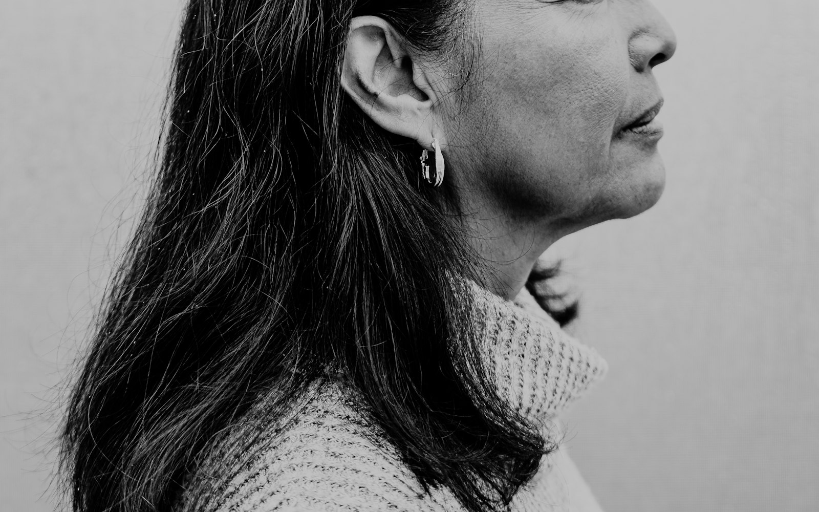 Mature woman in profile in soft window light, in black and white