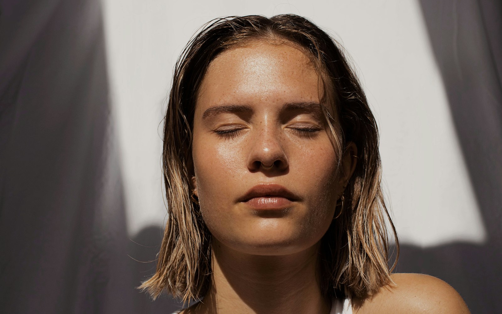Woman with fresh, bare-looking skin and slicked-back hair