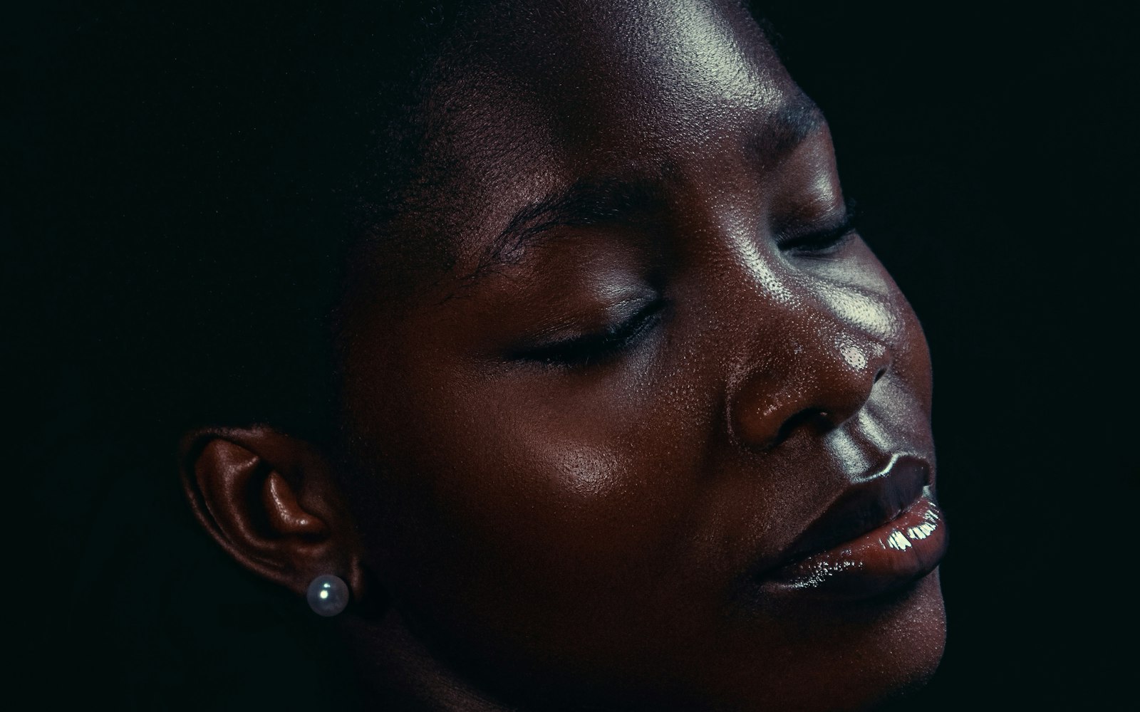Close-up of glowing deep skin with closed eyes