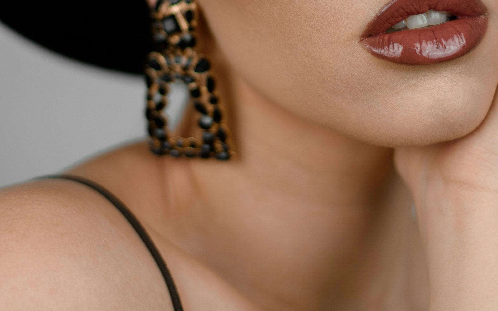 Glossy brown lips with statement earrings