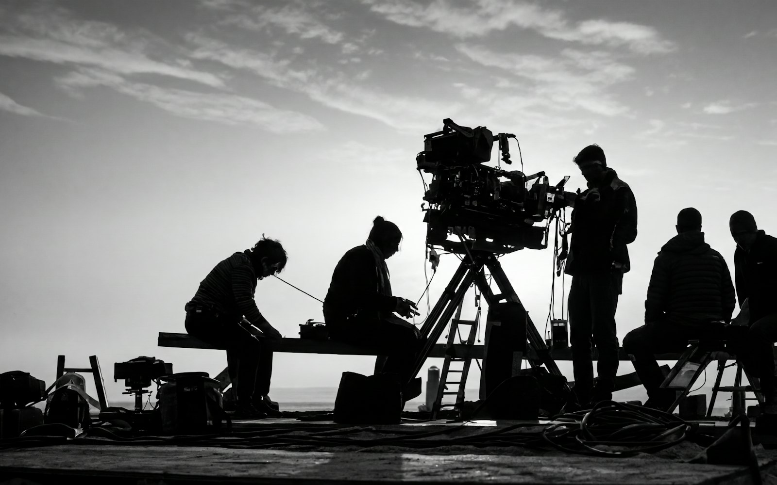 Silhouetted camera crew working on a rooftop set
