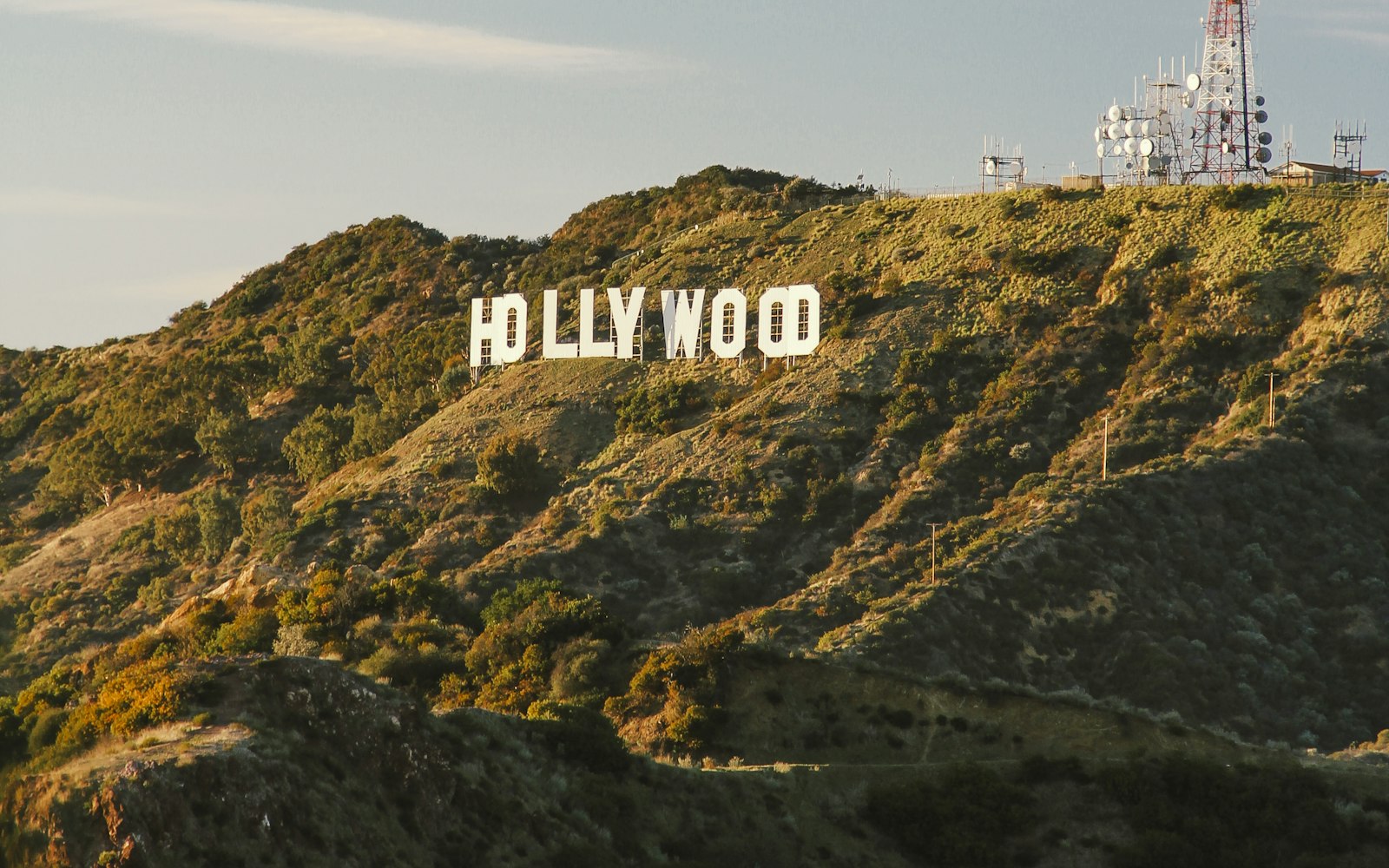 Hollywood sign on a green hillside above Los Angeles