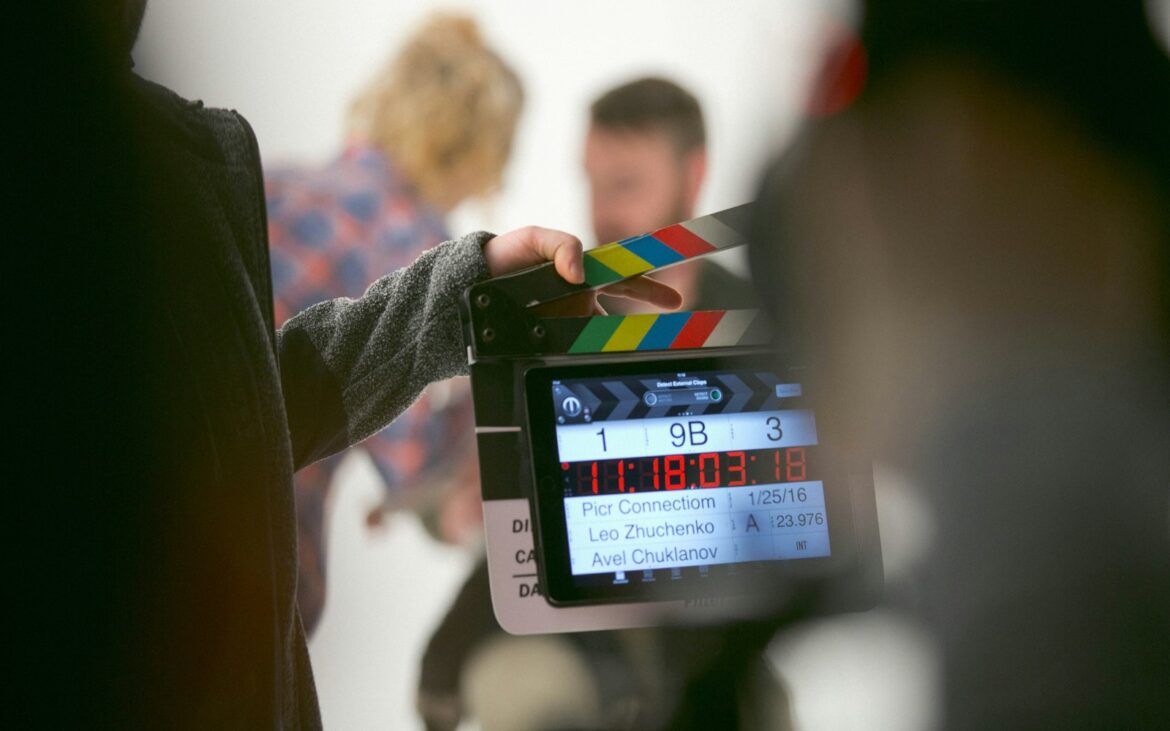 Crew member holding a digital slate on a film set