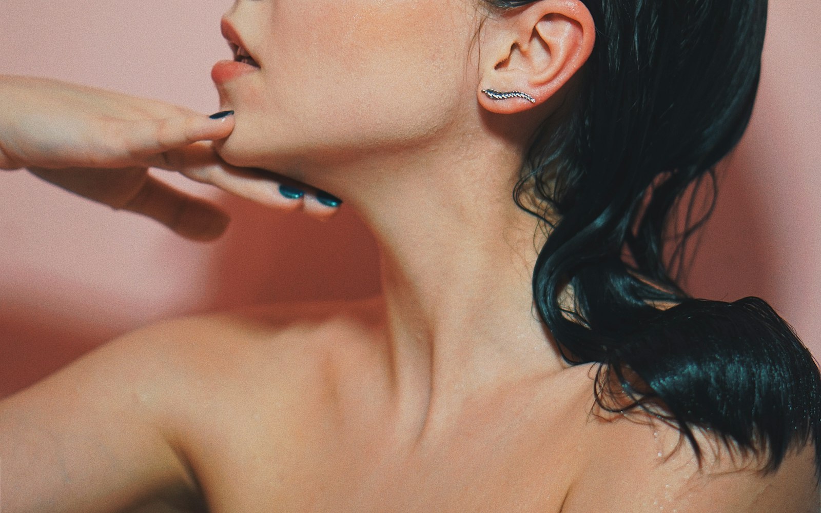 Editorial beauty portrait with soft skin and a hand at the jaw