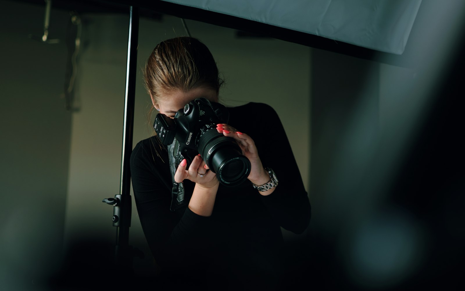 Photographer framing a shot with a camera in a studio