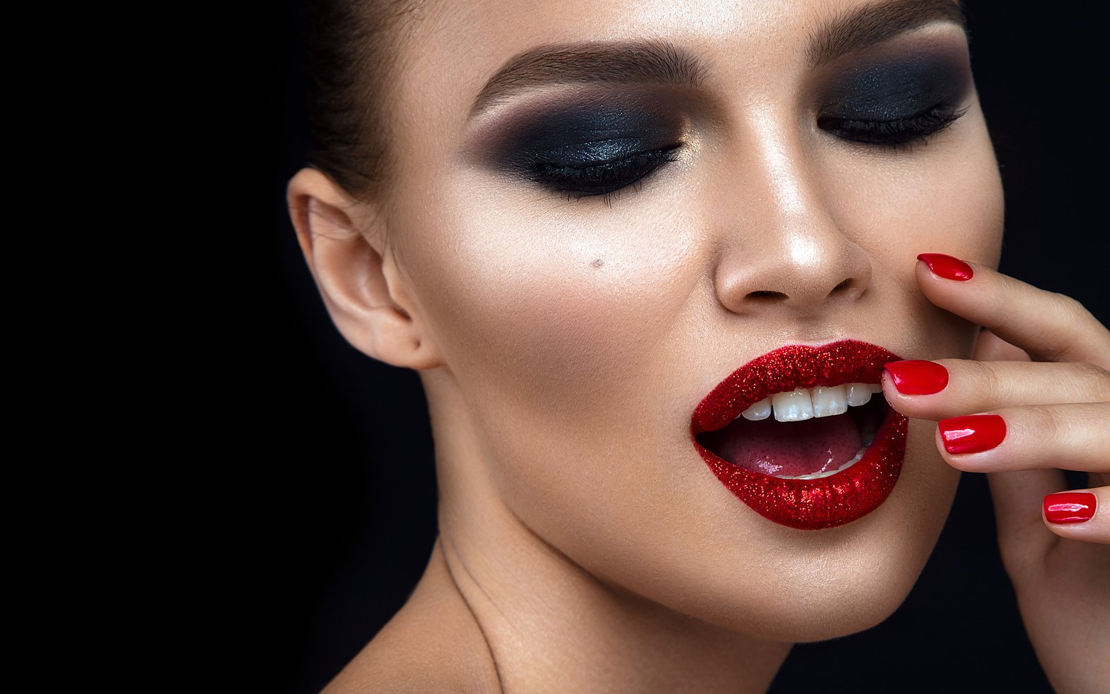 Model with smoky eyes and glittering red lip gloss