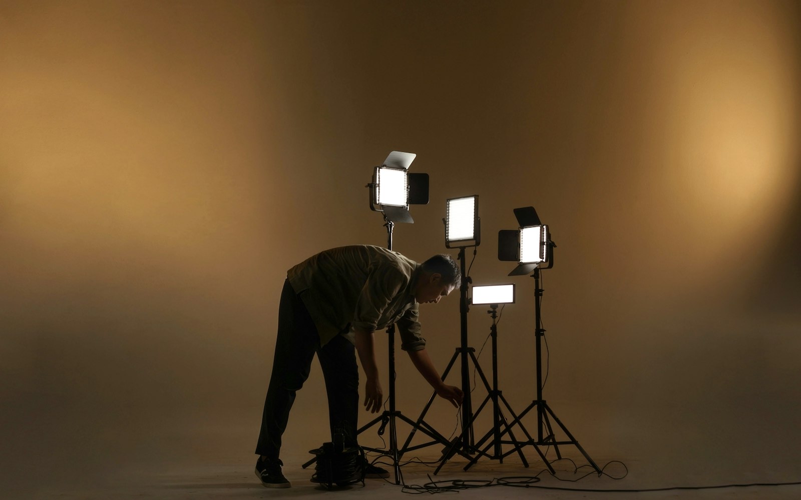 Crew member adjusting LED panel lights on stands