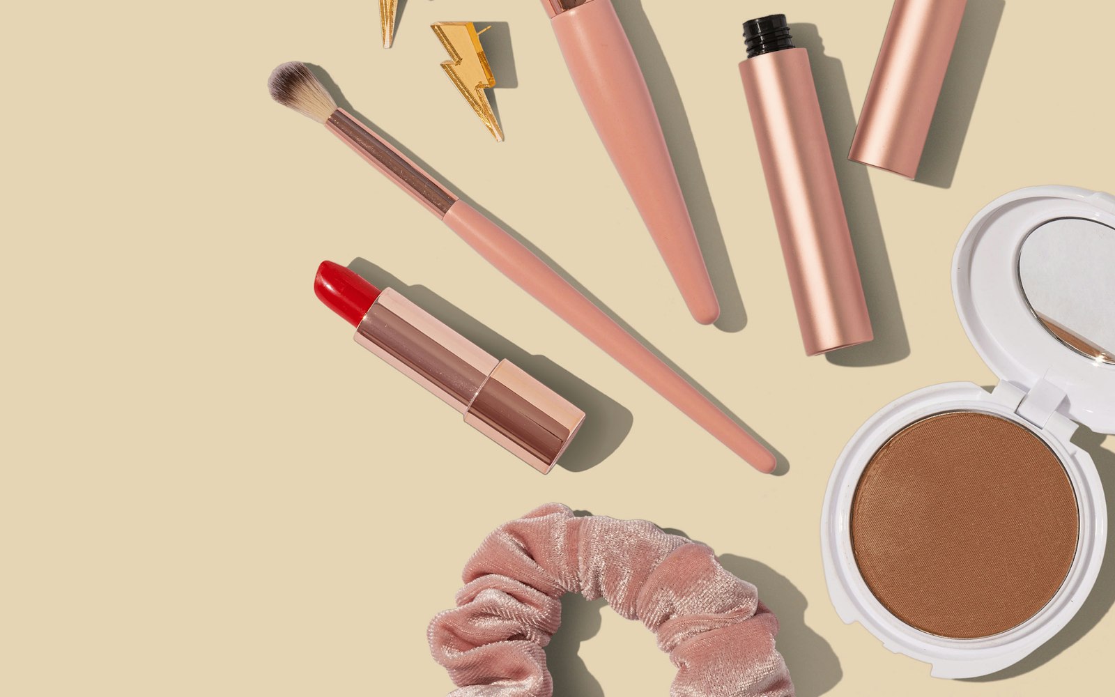 Pink and brown makeup brush set laid out on a table