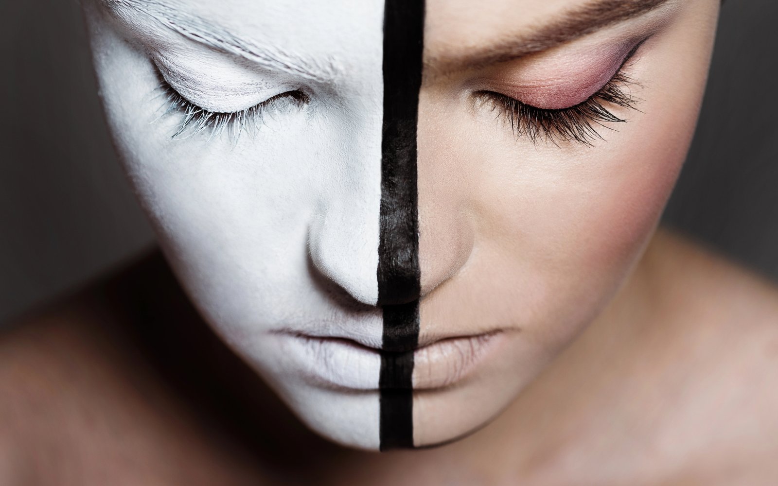 Model with a white-painted face split by a black graphic line