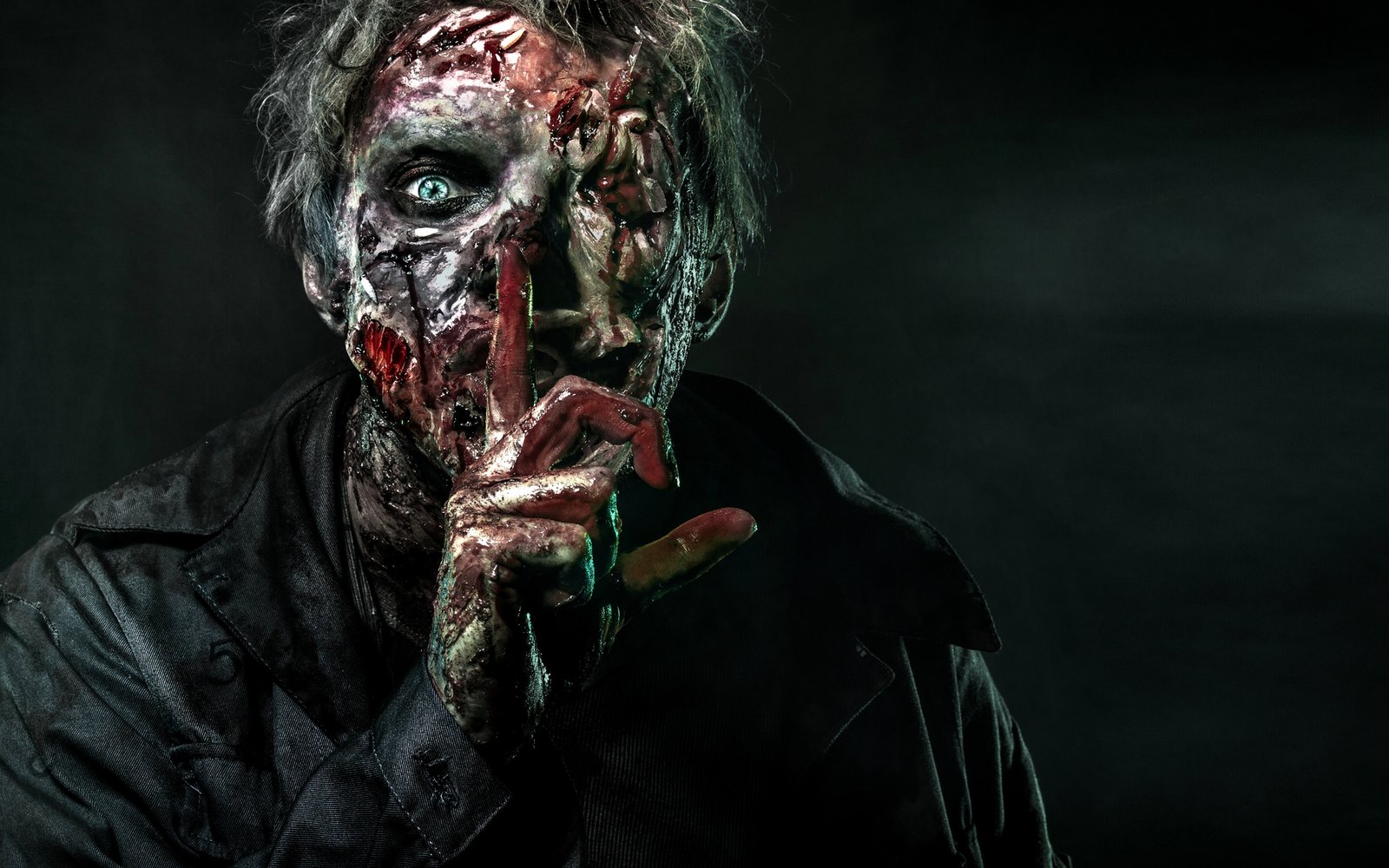 Close-up of a zombie character in full prosthetic makeup in smoke