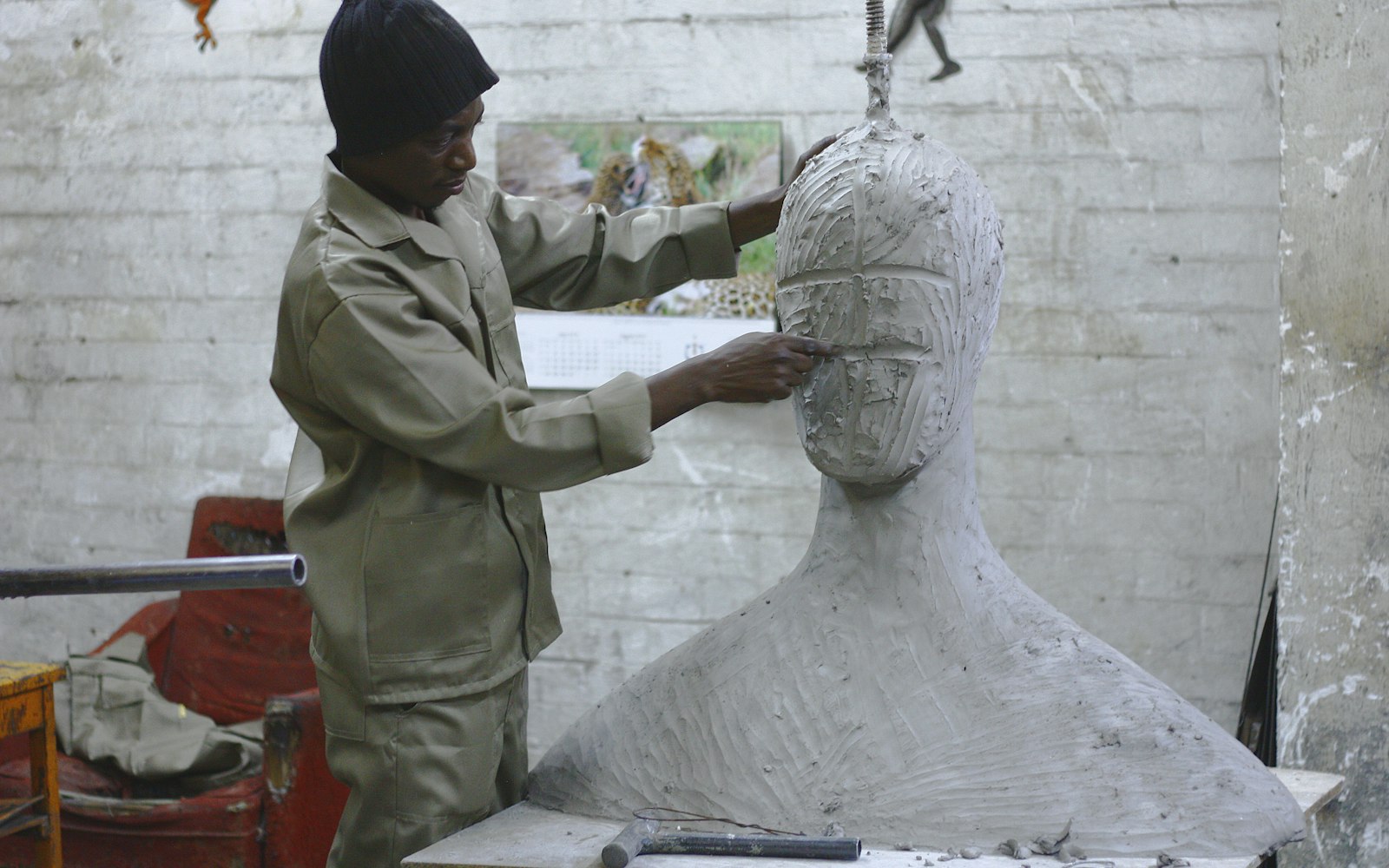 Sculptor shaping a clay head on a bust in a workshop