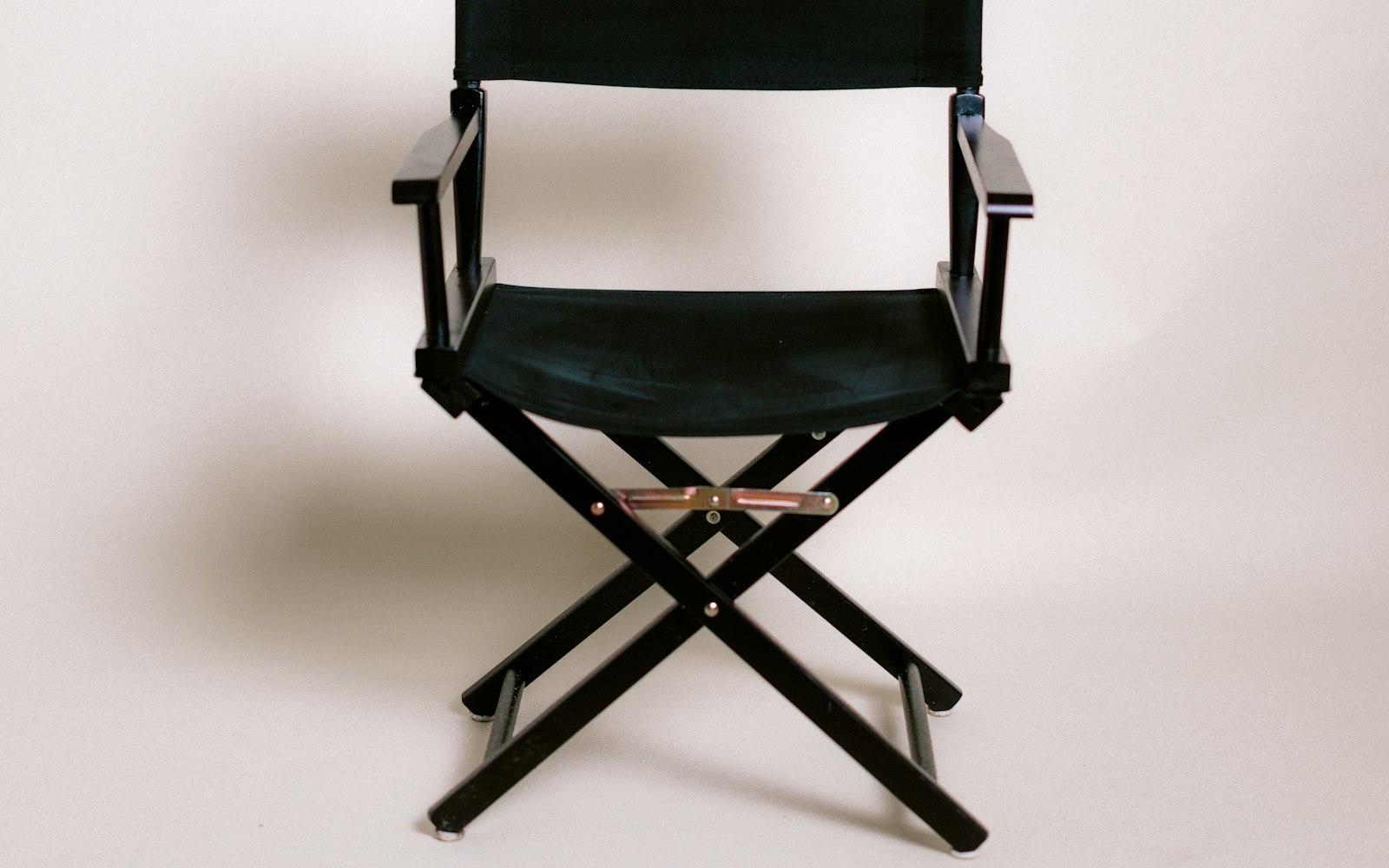 Black folding director's chair on a white background