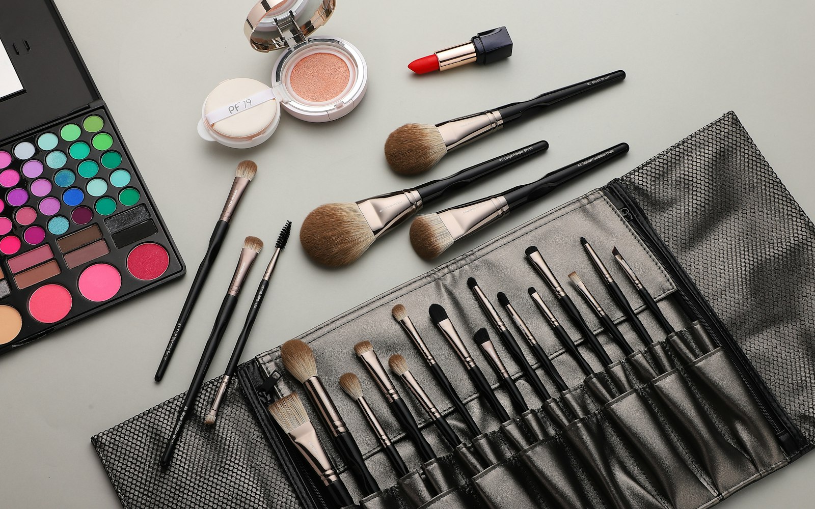 Brush roll and palette laid out beside loose brushes