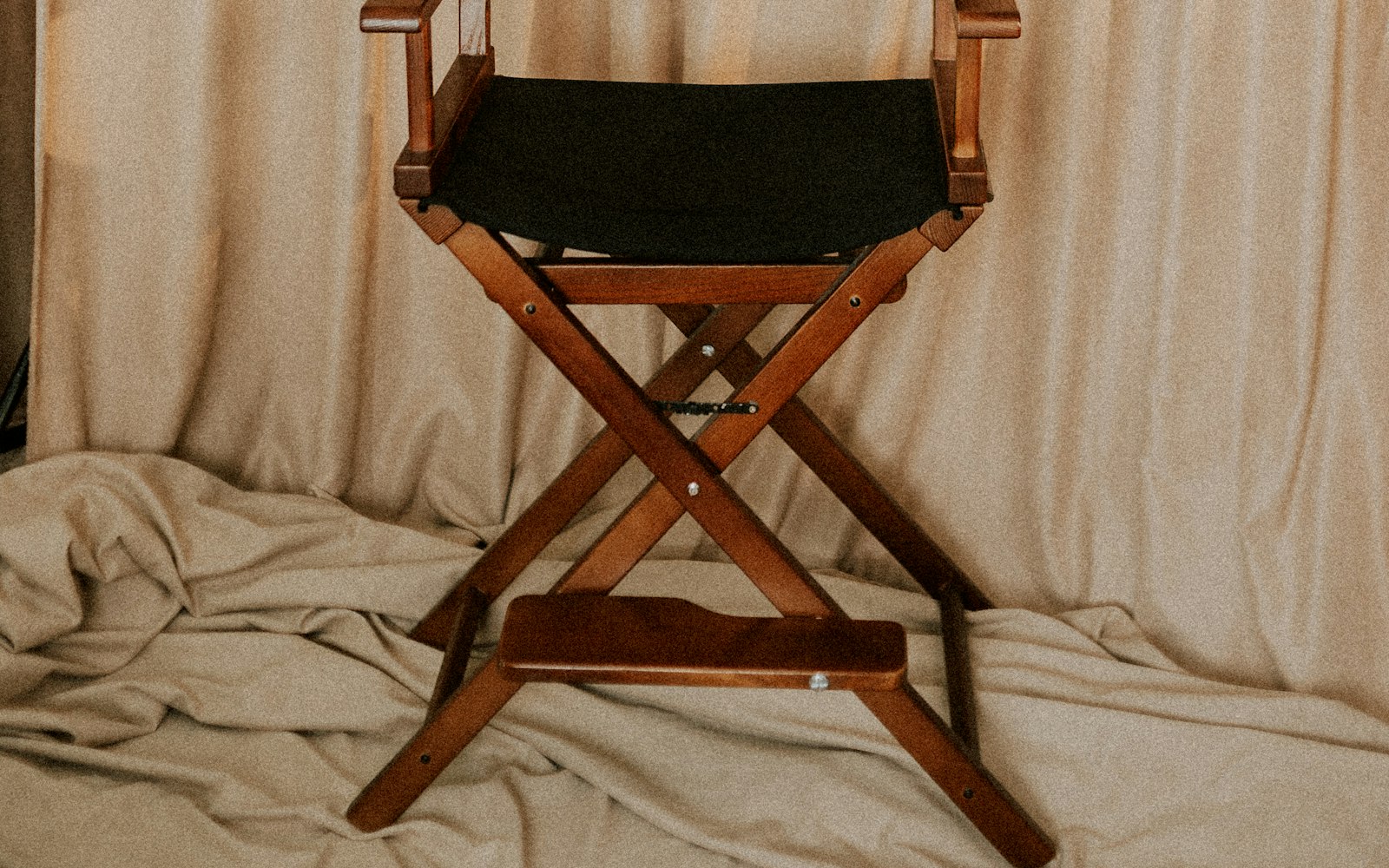 Wooden director's chair against draped linen
