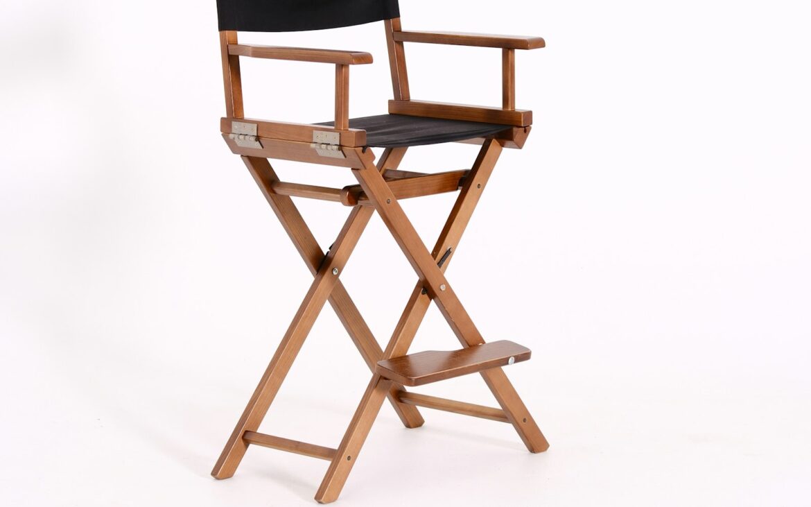 Tall wooden director's chair with a black canvas seat on white