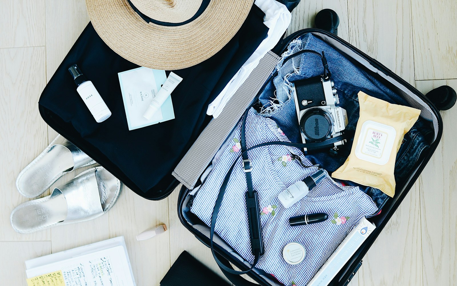 Open suitcase packed with toiletries, a camera and clothes