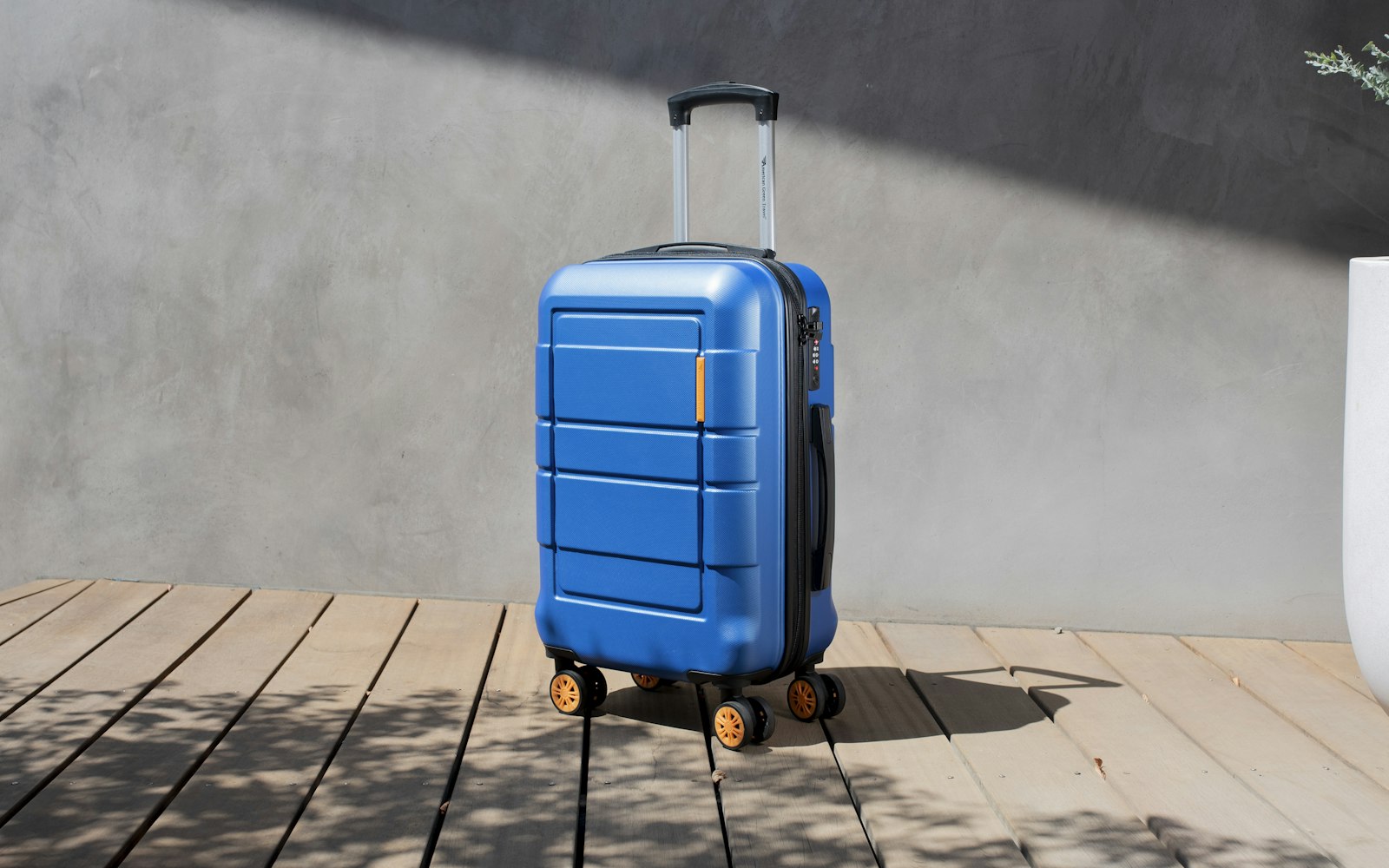 Blue rolling case standing on a wooden deck