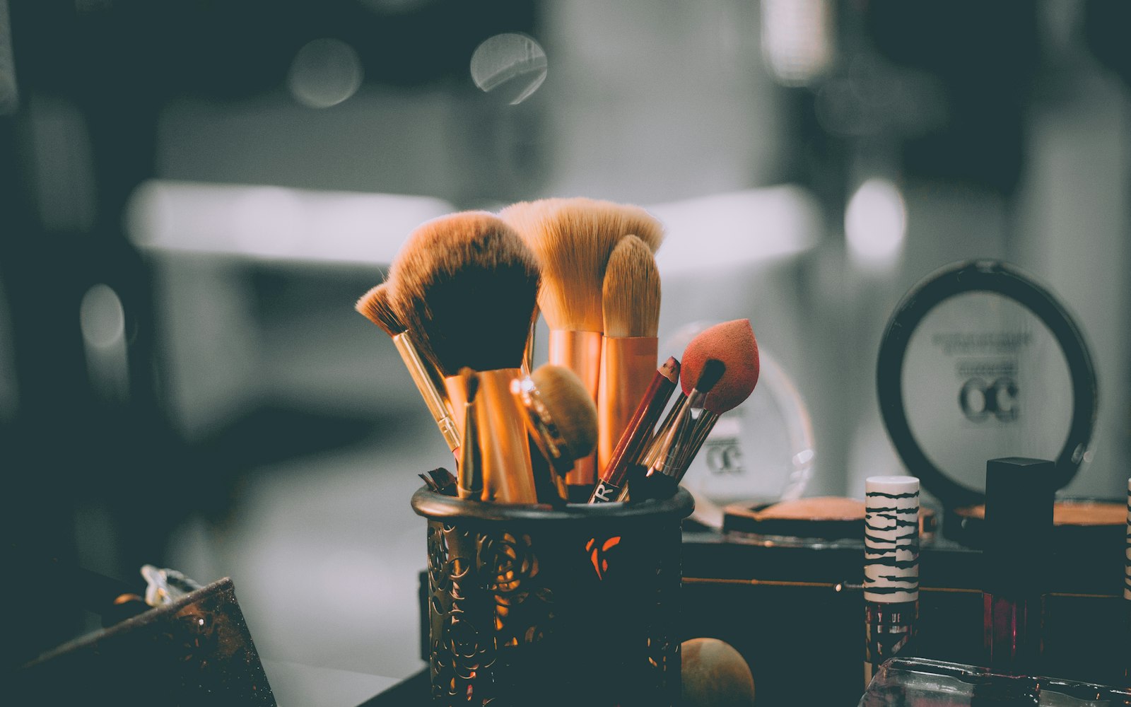 Brushes standing in a cup at a backstage makeup station