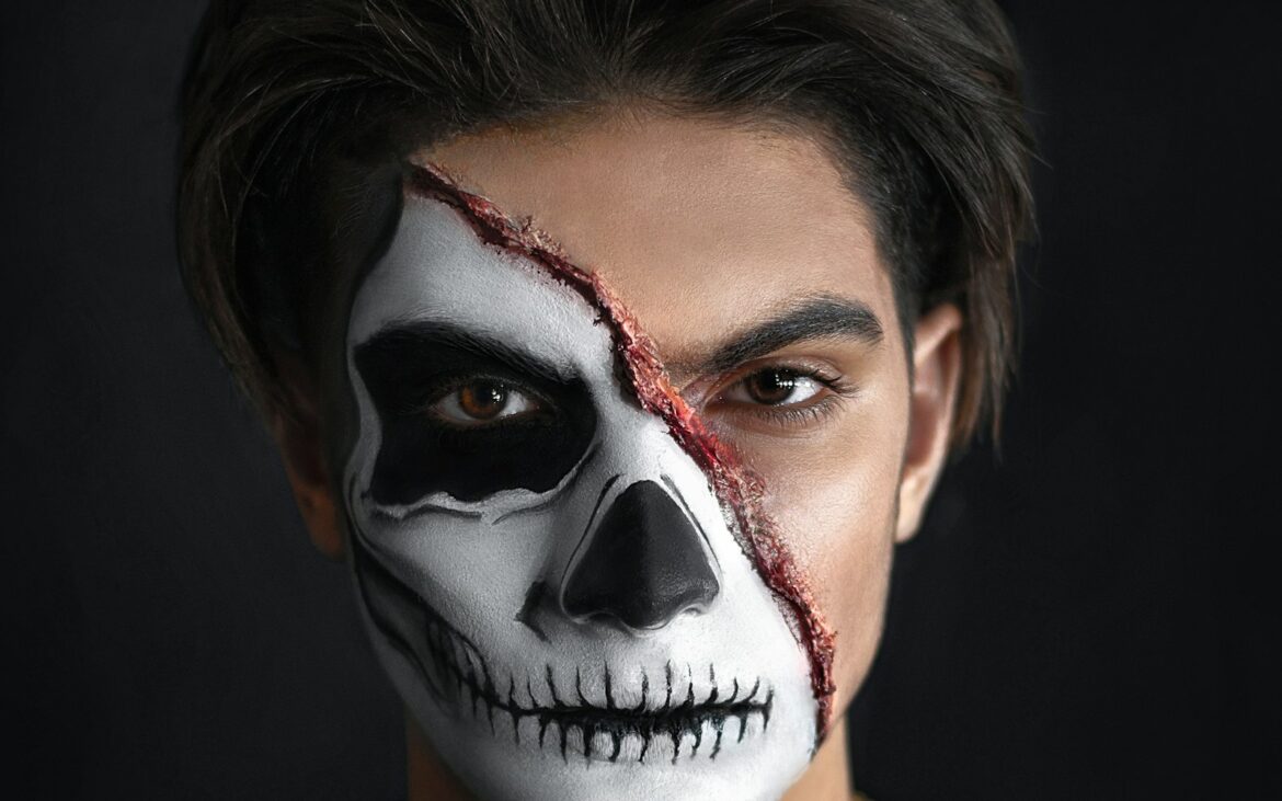 Half-face skull makeup with a sculpted slash wound across the cheek