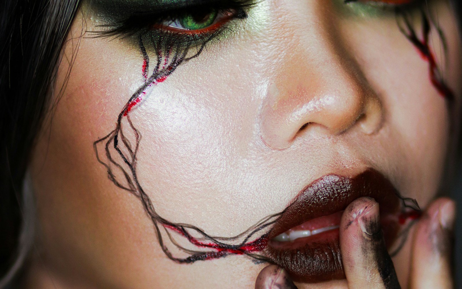 Close-up of dark vein and blood effects around the lips and eye