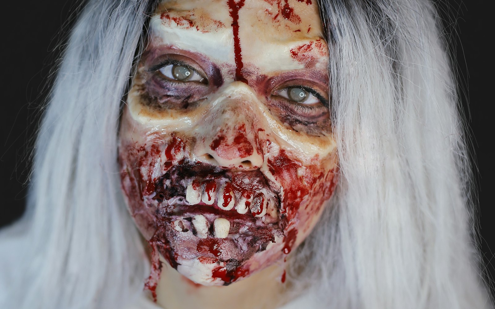 Full zombie makeup with sculpted wounds and decayed teeth