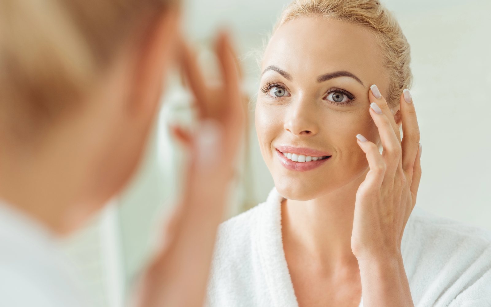 Woman checking her makeup in a dressing-room mirror
